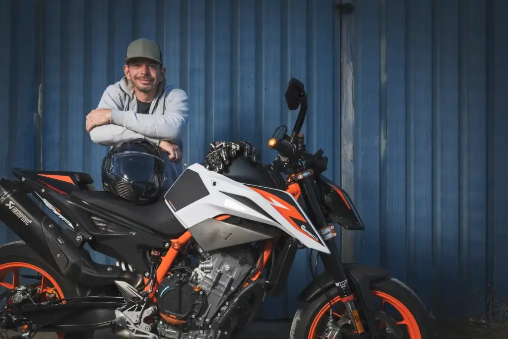 Portrait de Xavier Planchamp, moniteur de conduite, devant sa moto KTM