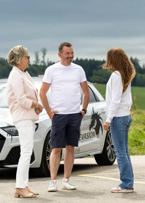 Xavier Planchamp devant sa voiture avec une élève et sa maman. Evasion auto-école